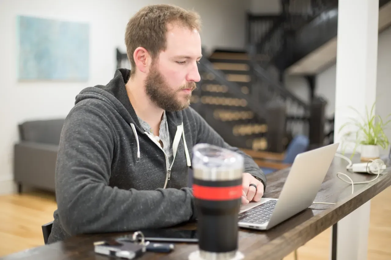 Eine Person arbeitet konzentriert am Laptop an einem Schreibtisch